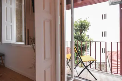 a door leading to a balcony with a yellow chair at Sweet Home Firmeza in Porto