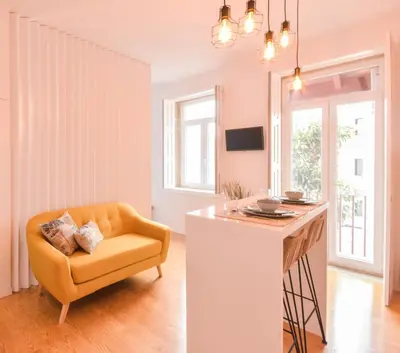 a living room with a yellow chair and a table at Sweet Home Firmeza in Porto