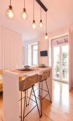 a kitchen with a large white island with two chairs at Sweet Home Firmeza in Porto