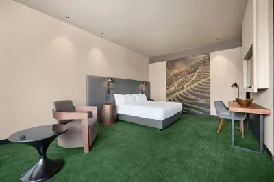 a waiting room with orange chairs and large windows at Hilton Porto Gaia in Vila Nova de Gaia