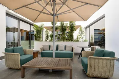 a patio with chairs and a table and an umbrella at Hilton Porto Gaia in Vila Nova de Gaia