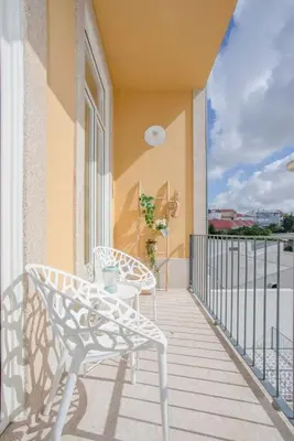 a patio with two chairs and a table on a balcony at Liiiving in Porto - Downtown Balcony Studio in Porto