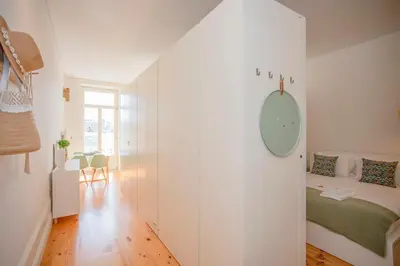 a small white room with a bed and a table at Liiiving in Porto - Downtown Balcony Studio in Porto