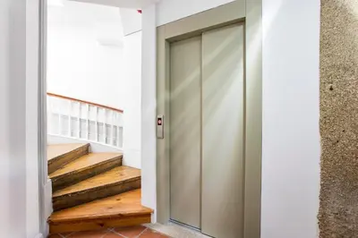 a pivot door in a hallway with stairs at Mouzinho Darling 1BR w/ AC in City Center by LovelyStay in Porto