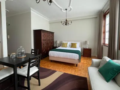 a bedroom with a bed and a table and a couch at Invicta Republica Studio in Porto