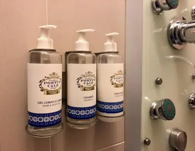 three bottles of cleaning products sitting on a bathroom door at Invicta Republica Studio in Porto