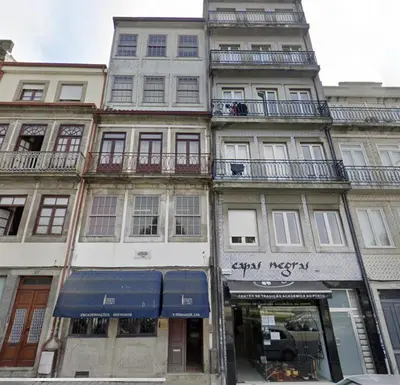 a tall building on a city street with a store at Invicta Republica Studio in Porto
