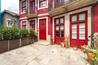 a red door on a red brick building at NorteSoul Porto à Vista in Vila Nova de Gaia