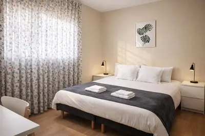 a bedroom with a bed with two towels on it at Porto à Vista in Vila Nova de Gaia