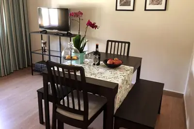 a dining room table with a bowl of fruit and a television at Porto à Vista in Vila Nova de Gaia