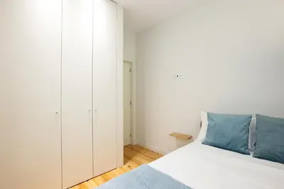 a white bedroom with a bed and a closet at North Side in Porto