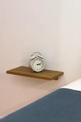 a clock sitting on a shelf next to a bed at North Side in Porto