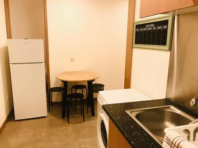 a small kitchen with a table and a refrigerator at Congregados Apartment in Porto