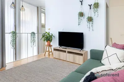 a living room with a flat screen tv and a couch at Stylish Triplex next to Ribeira in Porto