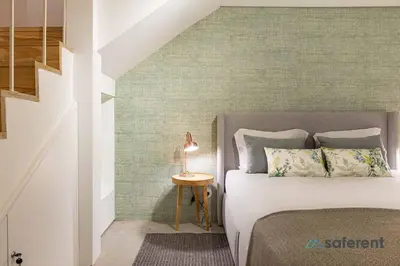 a bedroom with a bed and a table with a lamp at Stylish Triplex next to Ribeira in Porto