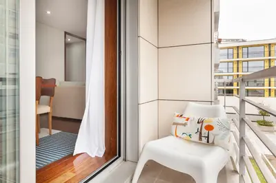 a white chair sitting on a balcony next to a window at D&S - Family Apartments II in Porto