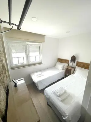 two beds in a room with two windows at Portoo Blue Apartments - Douro in Vila Nova de Gaia