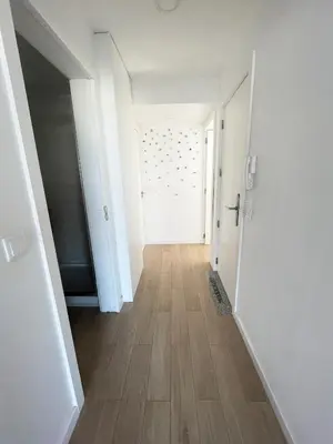 an empty hallway with a white door and a wooden floor at Portoo Blue Apartments - Douro in Vila Nova de Gaia