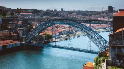 a blue bridge over a river with a city at Douro Golden Studio in Porto