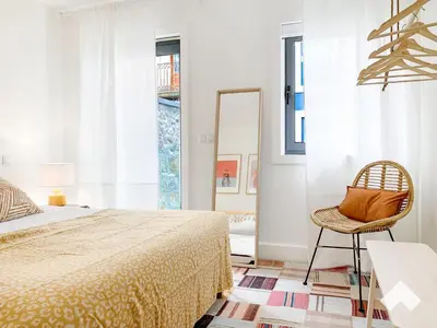 a bedroom with a bed and a chair and a mirror at The Wondrous Central Apartment in Porto