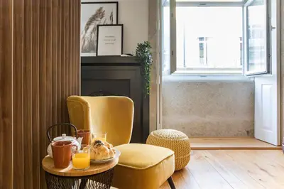 a room with a chair and a table with food on it at Mouzinho Darling Studio w/ AC in City Center by LovelyStay in Porto