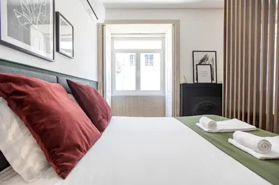 a bedroom with a bed with red and white pillows at Mouzinho Darling Studio w/ AC in City Center by LovelyStay in Porto