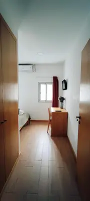 a room with a desk and a table and a window at Get Cozy in Porto