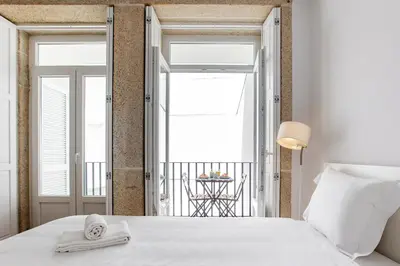 a bedroom with a white bed and a balcony at Flux Art Studio w/ AC & Balcony by LovelyStay in Porto