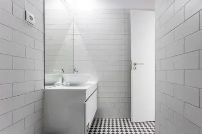 a white bathroom with a sink and a mirror at Flux Art Studio w/ AC & Balcony by LovelyStay in Porto