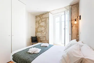 a bedroom with a bed with towels on it at Central Studio with Pool & Patio by LovelyStay in Porto