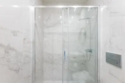 a shower with a glass door in a bathroom at Central Studio with Pool & Patio by LovelyStay in Porto
