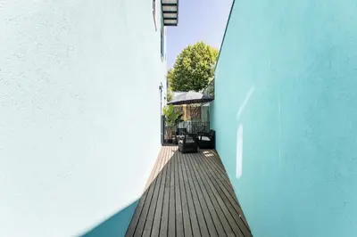 a wooden walkway between a white and blue building at Central Studio with Pool & Patio by LovelyStay in Porto