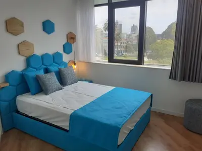a blue bed in a room with a large window at 3 Bedrooms Central Apartment with garage by Great&Cosy in Porto