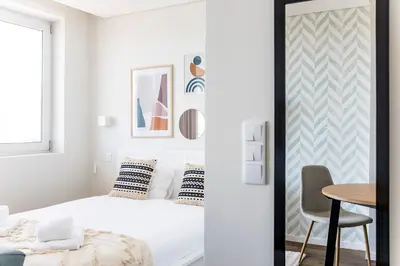 a bedroom with a bed and a table at Elegant Studio w/ AC & Balcony by LovelyStay in Porto