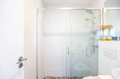 a bathroom with a shower with a glass door at Elegant Studio w/ AC & Balcony by LovelyStay in Porto