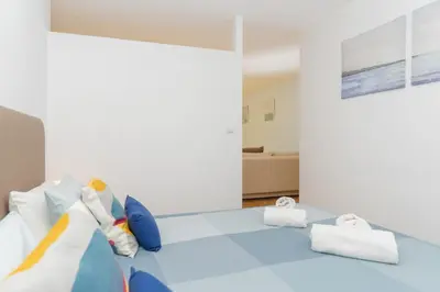 a room with a blue bed with white pillows at Sunny Oporto, Douro Apartments in Porto