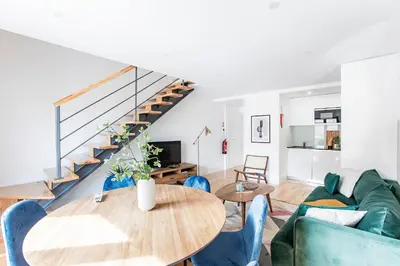 a living room with a table and blue chairs at Bright 3BR Flat w/ AC in City Center by LovelyStay in Porto