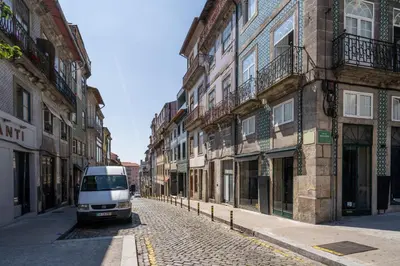 a van parked on a cobblestone street next to buildings at Host Wise - Urban Stylish Flat - Ace Location in Porto