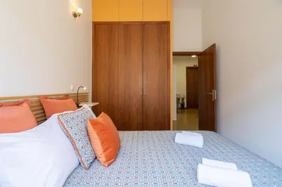 a bedroom with a bed with orange and white pillows at Host Wise - Urban Stylish Flat - Ace Location in Porto