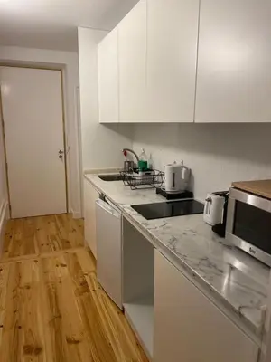 a kitchen with white cabinets and a counter top at Quiet Apartment with Terrace in the Heart of Porto by Great&Cosy in Porto