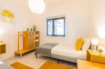 a white bedroom with a bed and a window at Casa Azul @ Jardim do Morro by BnBird in Vila Nova de Gaia