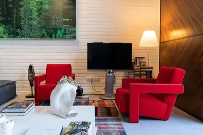 a living room with two red chairs and a tv at Arty Porto in Porto