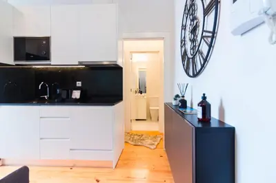 a kitchen with white cabinets and a black counter top at ON Apartments - Lapa Deluxe in Porto