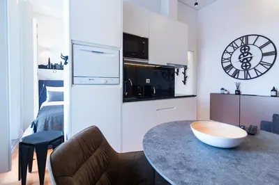 a living room with a table and a couch and a clock at ON Apartments - Lapa Deluxe in Porto