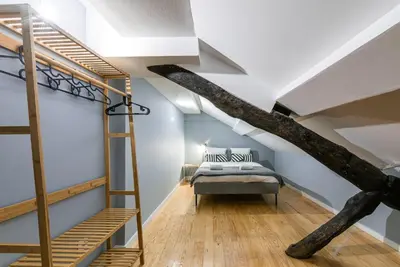 a loft bedroom with a bed and a ladder at GuestReady - Miragaia Rooftop in Porto