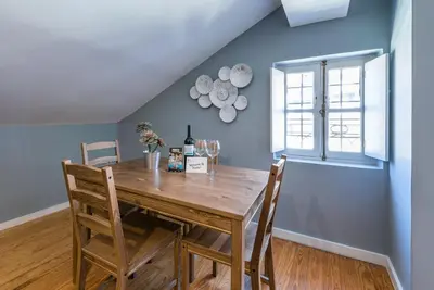 a dining room with a wooden table and chairs at GuestReady - Miragaia Rooftop in Porto