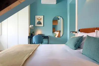 a bedroom with a bed with a blue wall at HM - Infante Riverside Apartment R in Porto
