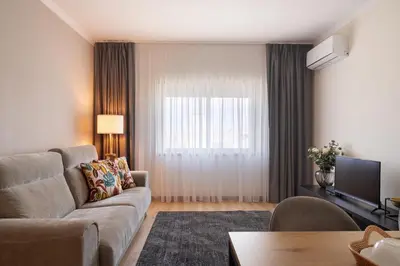 a living room with a couch and a television at Gaia Douro Apartment in Vila Nova de Gaia