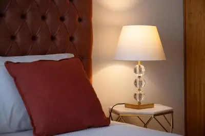 a bed with a red pillow and a lamp on a table at Gaia Douro Apartment in Vila Nova de Gaia