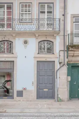 a building with a gray door on a street at Liiiving in Porto - Ribeira Design Apartment in Porto
